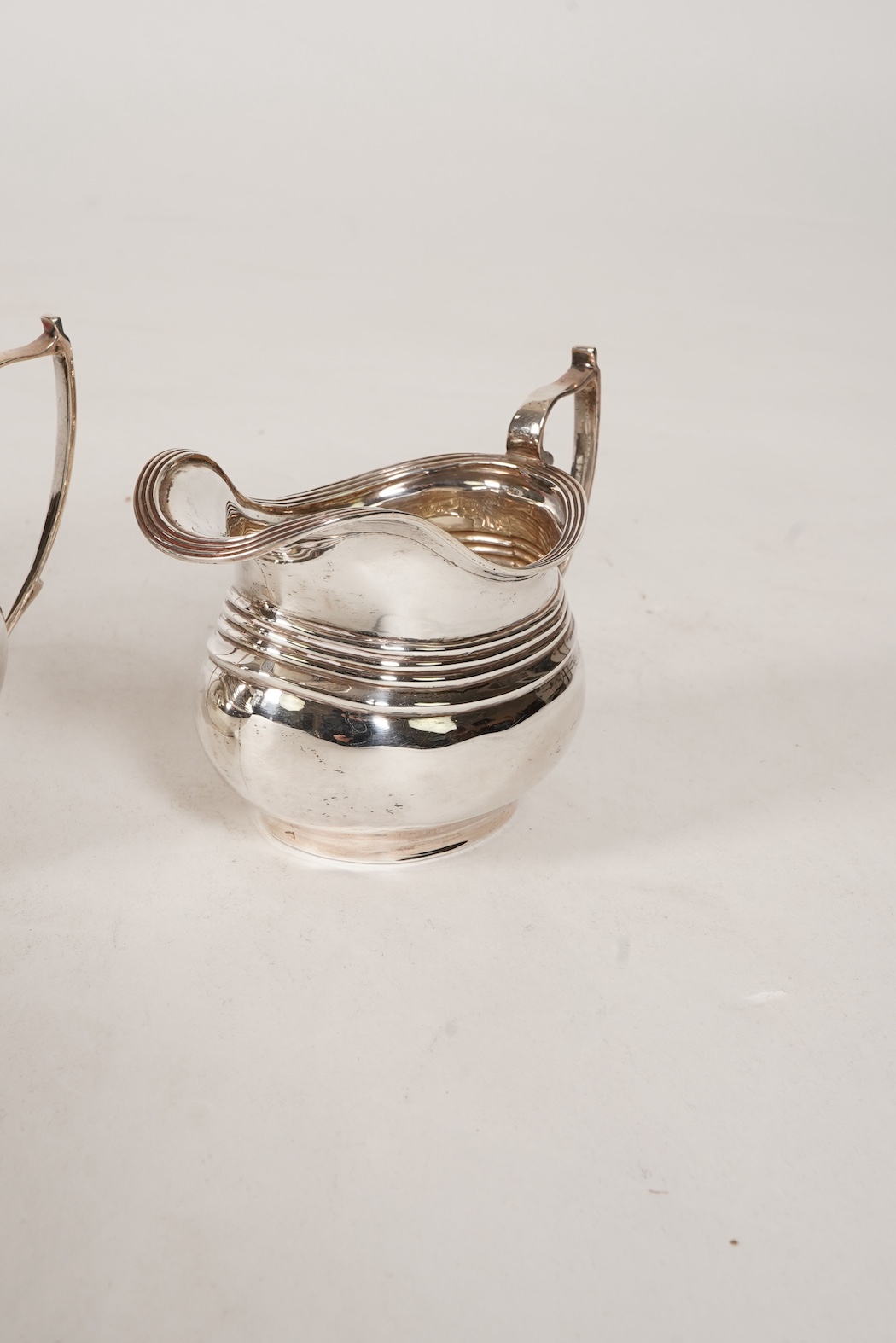 A George V four piece silver tea set, comprising teapot, hot water pot, sugar bowl and milk jug, by S. Blanckensee & Son Ltd